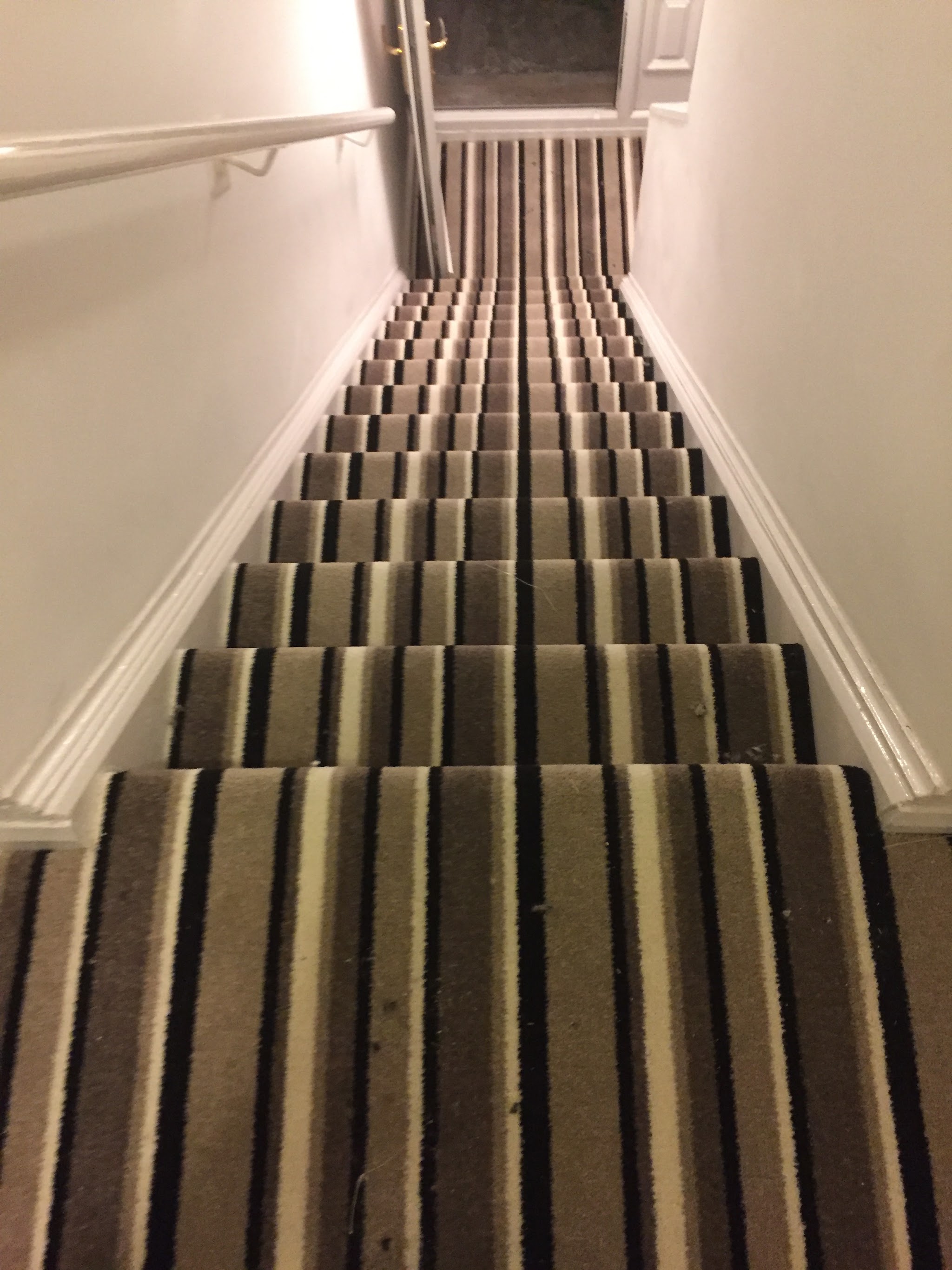 Striped carpet fitted up a narrow staircase