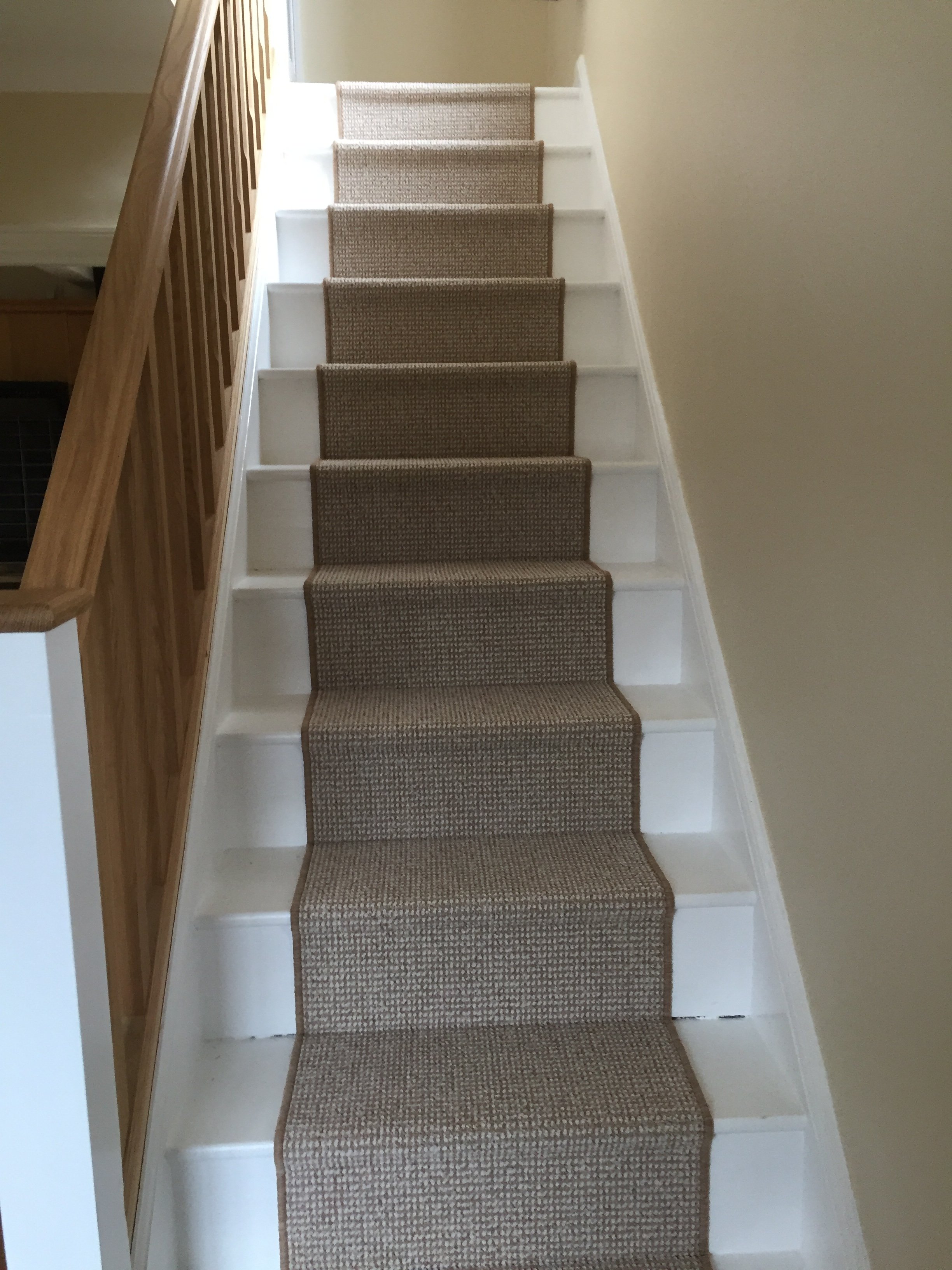 Stair runner with painted edges fitted on a white staircase